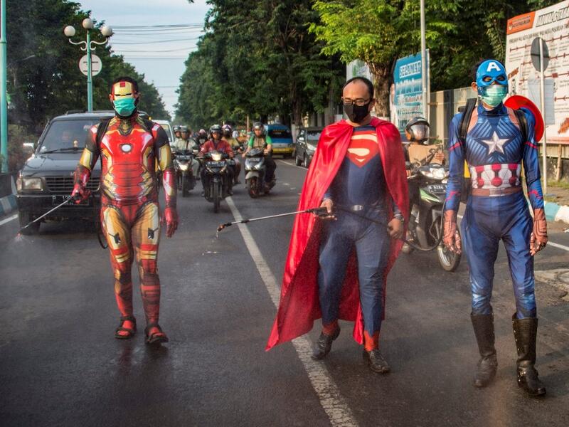 Indonesian police officers wearing superhero costumes on the street disinfect motorists' vehicles in Pasuruan, East Java on April 9, 2020, amid concert to the COVID-19 coronavirus. JUNI KRISWANTO / AFP