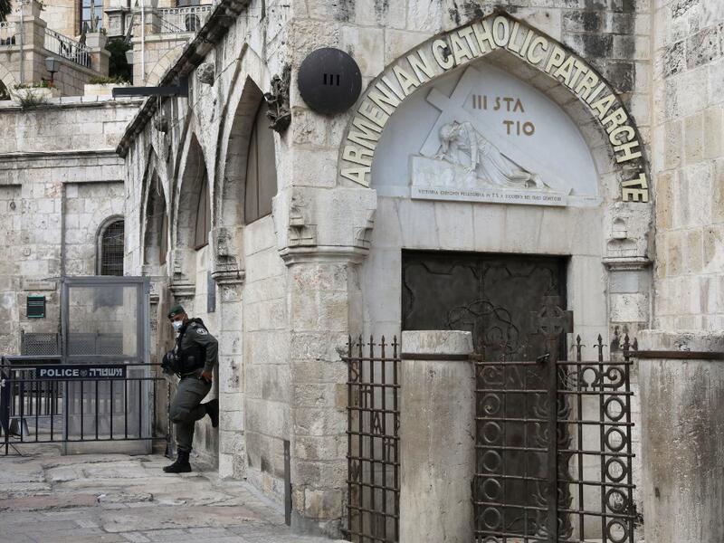 An Israeli border policeman wearing a protective mask stands guard by the third station of the Way of the Cross, also known as the Via Dolorosa, believed to be the route Jesus walked carrying the cross on the way to crucifixion, in Jerusalem's Old City, on April 7, 2020. All cultural sites in the Holy Land are shuttered, regardless of their religious affiliation, as authorities seek to forestall the spread of the deadly respiratory disease, which will prevent Christians from congregating for the Easter serv