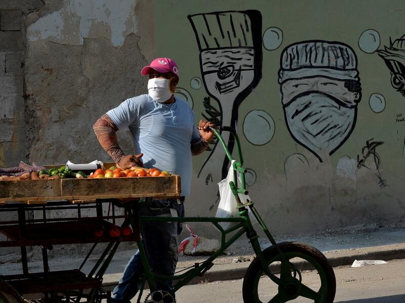 A fruits and vegetables seller wears a face mask in Havana, on April 11, 2020 amid the new coronavirus (COVID-19) pandemic. Cuba hit out at the United States on Friday over its nearly 60-year-old embargo against the island nation, which Havana described as "even more cruel" given the suffering caused by the new coronavirus pandemic. The communist-run single-party island is finding it tough to source medical supplies and has already recorded 620 coronavirus cases and 16 deaths. YAMIL LAGE / AFP