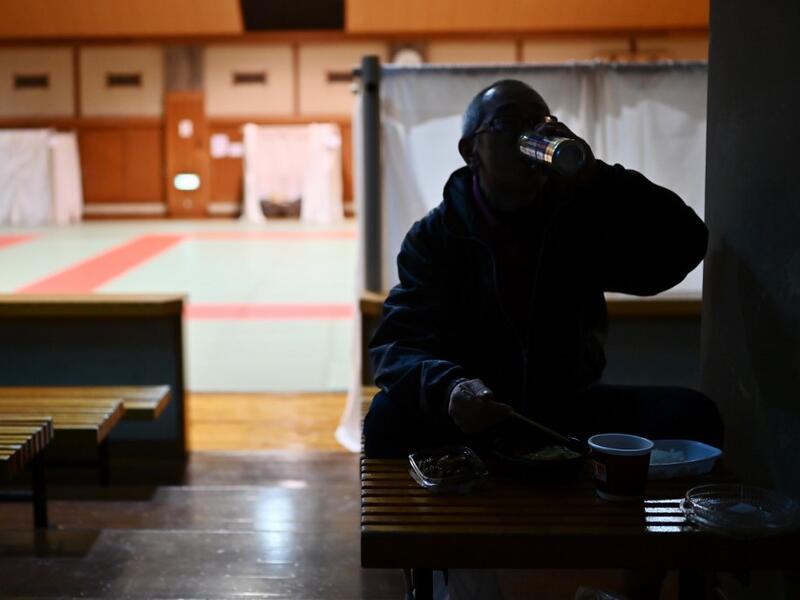Katsuya Asao, 54, eats before resting at a shelter provided by Kanagawa prefecture for the people, who can’t afford to rent an apartment and used to stay at designated internet cafes, which are closed due to the COVID-19 coronavirus outbreak state of emergency, at a Judo sport hall in Yokohama, Kanagawa prefecture on April 13, 2020. CHARLY TRIBALLEAU / AFP