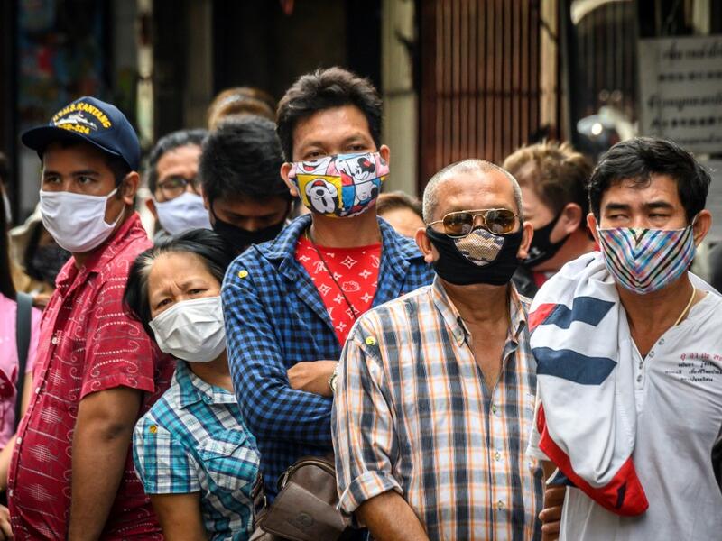 People wearing face masks amid fears of the spread of COVID-19 coronavirus line up to sell their jewelries in front of a gold shop in Bangkok's Chinatown on April 15, 2020. Hundreds of Bangkok residents rushed to goldsmith shops in order to sell their jewelries as gold prices reached its highest levels since 2012. Mladen ANTONOV / AFP