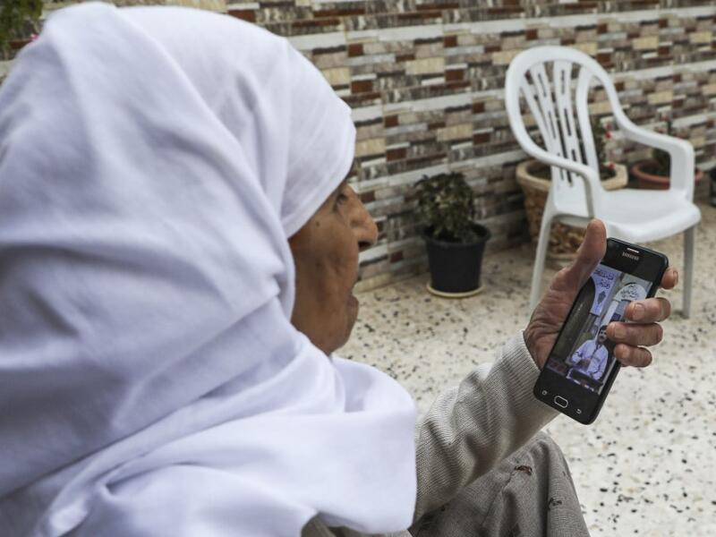 A Palestinian woman watches on her phone a sermon recorded and broadcast by a preacher from an empty mosque, due to the COVID-19 coronavirus pandemic, in the village of Salem east of Nablus in the occupied West Bank on the first Friday of the Muslim holy month of Ramadan on April 24, 2020. JAAFAR ASHTIYEH / AFP