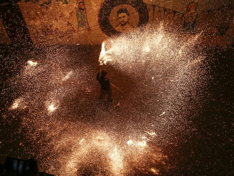 A Palestinian youth swings a homemade sparkler firework as people celebrate on a night of the Muslim holy month of Ramadan in Rafah refugee camp, in the southern Gaza Strip, on May 4, 2020. MAHMUD HAMS / AFP