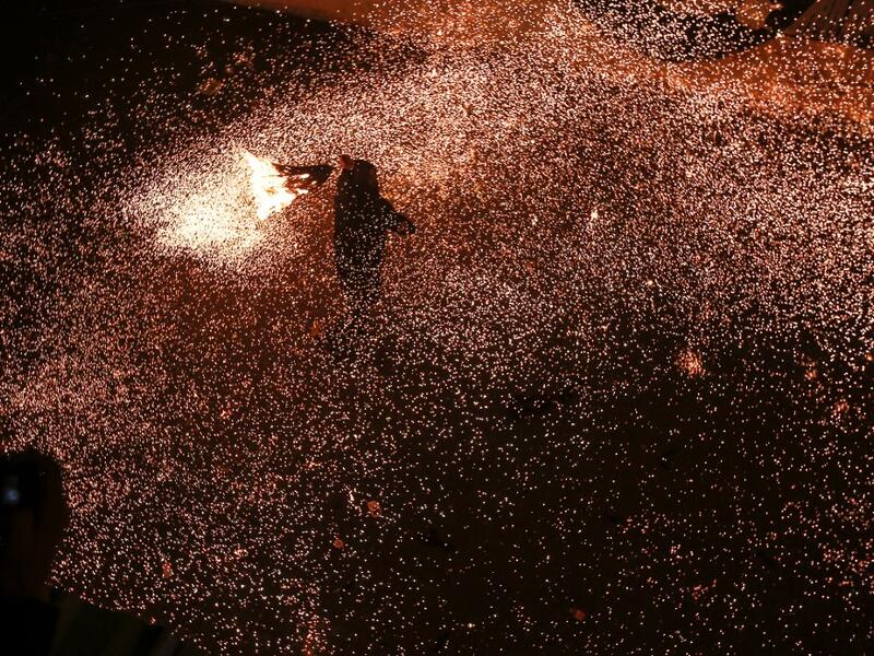 A Palestinian youth swings a homemade sparkler firework as people celebrate on a night of the Muslim holy month of Ramadan in Rafah refugee camp, in the southern Gaza Strip, on May 4, 2020. MAHMUD HAMS / AFP