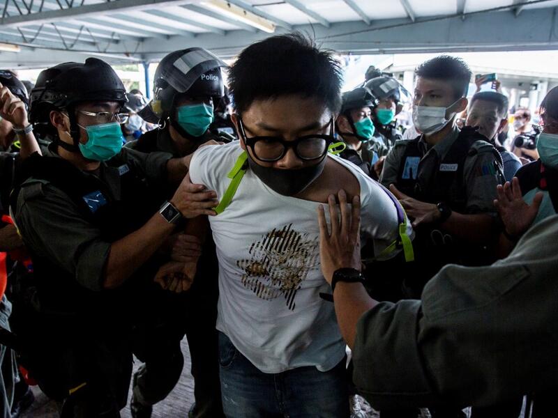 Police officers arrest a pro-democracy demonstrator (C) during a pro-democracy protest calling for the city's independence in Hong Kong on May 10, 2020. ISAAC LAWRENCE / AFP