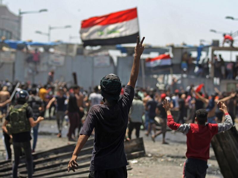 An Iraqi protester gestures the victory sign as some clash with security forces on Al-Jumhuriyah bridge in the capital Baghdad, during an anti-government demonstration on May 10,2020. Modest anti-government rallies resumed in some Iraqi cities today, clashing with security forces and ending months of relative calm just days after Prime Minister Mustafa Kadhemi's government came to power. AHMAD AL-RUBAYE / AFP
