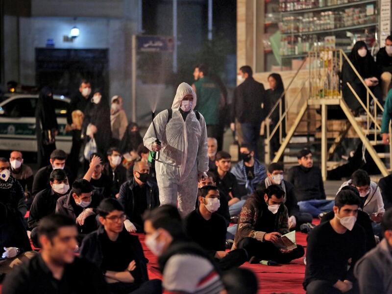 Iranians, some wearing face masks against the Covid-19 coronavirus, attend Laylat al-Qadr prayers, one of the holiest nights during the Muslim fasting month of Ramadan, outside a mosque in the Tehran, on May 13, 2020. ATTA KENARE / AFP