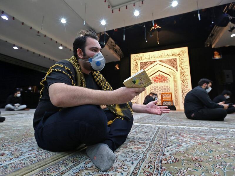 An Iranian man wearing a face mask against the Covid-19 coronavirus attends Laylat al-Qadr prayers, one of the holiest nights during the Muslim fasting month of Ramadan, outside a mosque in the Tehran, on May 13, 2020. ATTA KENARE / AFP