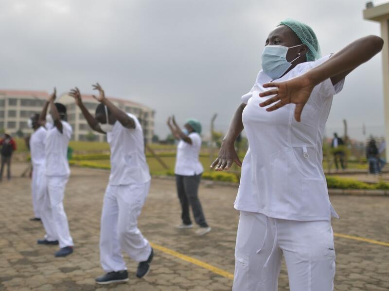 Nurses assigned to the Infectious Diseases Unit (IDU) at the Kenyatta University Hospital dance during a Zumba class held at the hospital compound in Nairobi, on May 17, 2020. Coinciding with the morning shift rotation the class, aimed to offer some respite to nurses charged with the management of patients infected with COVID-19 coronavirus, was organised by the Nursing Council of Kenya (NCK) and the Kenyatta Univesity Teaching, Refferal and Research Hospital in the Kenyan capital. TONY KARUMBA / AFP