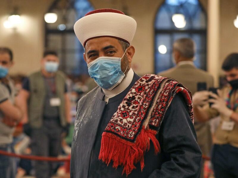 A Muslim cleric takes part in a morning prayer to celebrate the Eid al-Fitr holiday while wearing a protective mask due to the COVID-19 pandemic, at Mohammed al-Amin Mosque in the Lebanese capital Beirut's downtown district on May 24, 2020. ANWAR AMRO / AFP