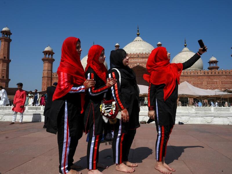 Muslim women take selfies after offering Eid al-Fitr prayers at the Badshahi Mosque in Lahore on May 24, 2020. Muslims around the world began marking a sombre Eid al-Fitr on May 24, many under coronavirus lockdown, but lax restrictions offer respite to worshippers in some countries despite fears of skyrocketing infections. Arif ALI / AFP