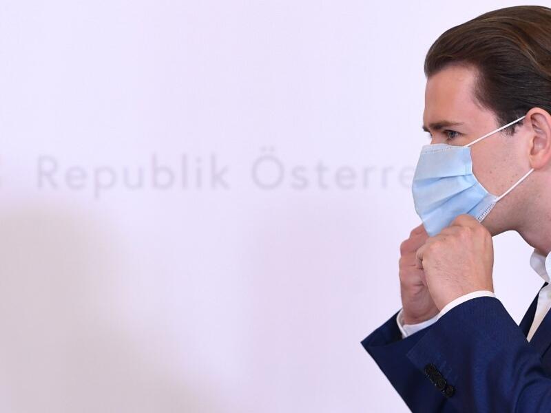 Sebastian Kurz, Austria's Chancellor and leader of Austria's People's party (OeVP), takes his face protection mask off as he arrives to give a press conference at the Chancellery in Vienna, amid the novel coronavirus / COVID-19 pandemic on May 25, 2020. HELMUT FOHRINGER / APA / AFP