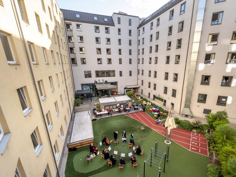 Guests of Zeitgeist Hotel listen from their rooms to singers Monika Medek and Dagmar Dekanovsky and the Camerata Carnutum orchestra, during a window concert (Fensterkonzert) in Vienna on May 30, 2020, as hotels have reopened in Austria amid the novel coronavirus pandemic. JOE KLAMAR / AFP