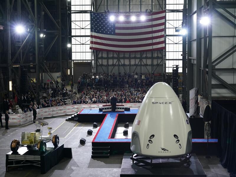 US President Donald Trump speaks near a SpaceX Crew Dragon capsule at a press briefing after the launch of the SpaceX Falcon 9 rocket and Crew Dragon spacecraft on NASA's SpaceX Demo-2 mission to the International Space Station from NASA's Kennedy Space Center in Cape Canaveral, Florida on May 30, 2020. Trump travels to Kennedy Space Center in Florida to watch the launch of the MANDEL NGAN / AFP