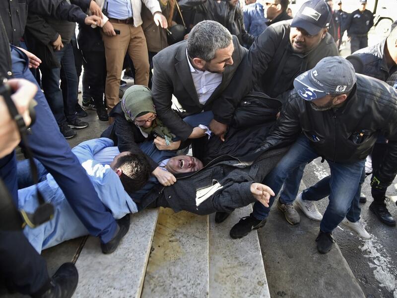 In this file photo taken on February 28, 2019, Samir Benlarbi (C), an Algerian opposition figure of the "Hirak" movement, tries to stop plain clothes policemen from detaining a protester participating in a rally organised by journalists against alleged censorship of coverage of protests against a fifth term for veteran President Abdelaziz Bouteflika in Algiers. Karim Tabbou and Samir Benlarbi, two of the main figures of Algeria's "Hirak" protest movement, will soon be freed under presidential pardons, said 