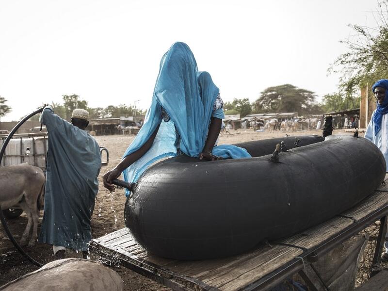 Fulani herders fill up their water tanks to take back to their camp at a unofficial herders market in Barkedji on May 28, 2020. Access to water comes at a price, many families must travel up to ten kilometres everyday to fill up their water supply, which then will be used for their livestock and themselves. COVID-19 coronavirus restrictions have closed down markets and regional movement, as a result Fulani herders are struggling to move to areas with more grazing land for there live stock. JOHN WESSELS / AF