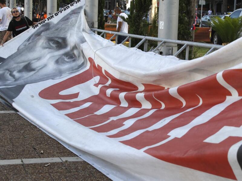 A protester prepares a placard bearing the portrait of Israeli Prime Minister Benjamin Netanyahu during a protest in Tel Aviv's Rabin Square on June 6, 2020, to denounce Israel's plan to annex parts of the occupied West Bank. JACK GUEZ / AFP