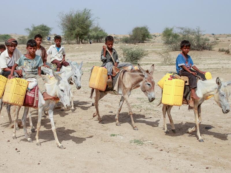 Yemeni children riding donkeys arrive to fill their jerrycans with water from a cistern at a make-shift camp for the internally displaced, in the northern Hajjah province, on June 7, 2020, amid a severe shortage of water. ESSA AHMED / AFP