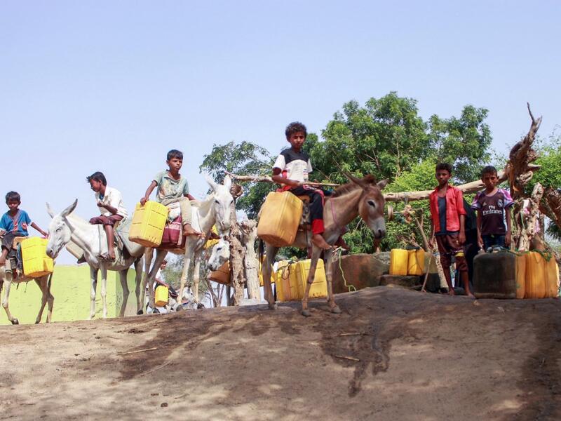 Yemeni youths, some riding donkeys, wait to fill their jerrycans with water from a cistern at a make-shift camp for the internally displaced, in the northern Hajjah province, on June 7, 2020, amid a severe shortage of water. ESSA AHMED / AFP
