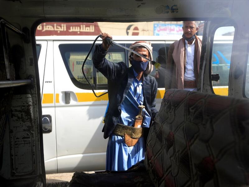 A Yemeni worker sprays disinfectant inside a van used for public transportation in the capital Sanaa, during the ongoing novel coronavirus pandemic crisis, on June 10, 2020. MOHAMMED HUWAIS / AFP