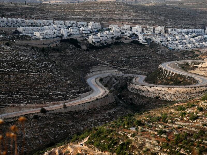 A serpentine road extends between the Jewish settlement of Givat Zeev (background) from Palestinian villages near the Israeli-occupied West Bank city of Ramallah, on June 10, 2020. Israel intends to annex West Bank settlements and the Jordan Valley, as proposed by US President Donald Trump, with initial steps slated to begin from July 1.  Ahmad GHARABLI / AFP