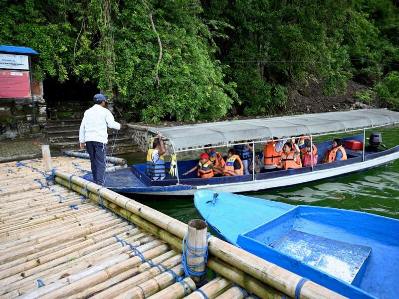 This picture taken on February 20, 2020 shows locals visiting a cemetery where Bali's Trunyanese people hold open-air burials - before restrictions were implemented due to the COVID-19 coronavirus - near the village of Trunyan in Bangli Regency, near Lake Batur on Bali island. SONNY TUMBELAKA / AFP