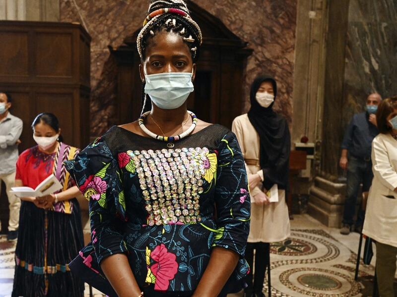 Faithful, wearing protective face masks over their traditional dress and respecting security distances, attend a vigil prayer for the deceased would be migrants as part of the International Migrants Day, in Rome's Basilica of Our Lady in Trastevere neighbourhood on June 18, 2020. The Community of Sant'Egidio organised a prayer for all 2039 people died in the Mediterranean during the 2019, speaking if even their name is today unknown to men, they are in the heart of God. Vincenzo PINTO / AFP