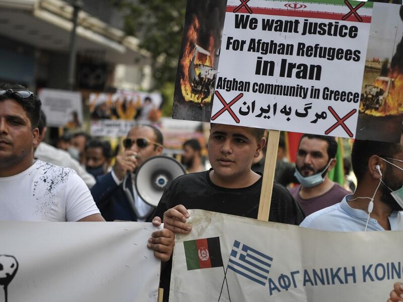 Afghans living in Athens carry a placard, demanding rights for Afghan refugees in Iran, as they participate with others in a rally in Athens on June 20, 2020, marking World Refugee Day, demanding rights and housing for refugees and migrants in Greece. Louisa GOULIAMAKI / AFP