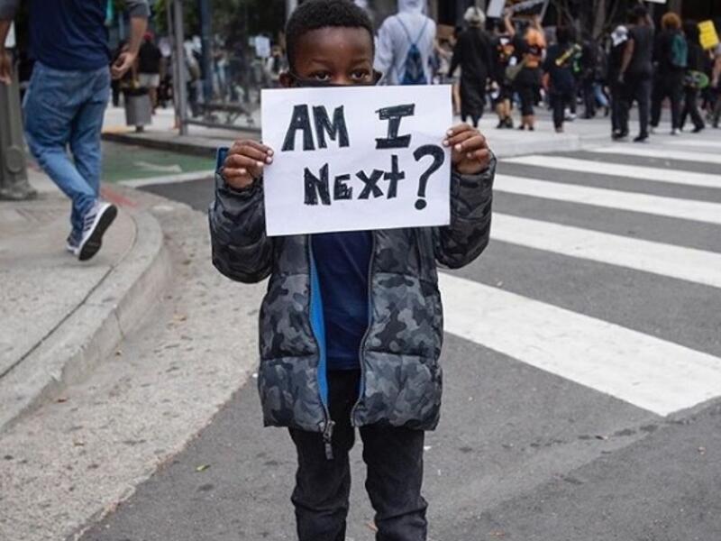 A boy holds a sign during a protest Friday in downtown Los Angeles over the death of George Floyd (unicefus/Instagram)