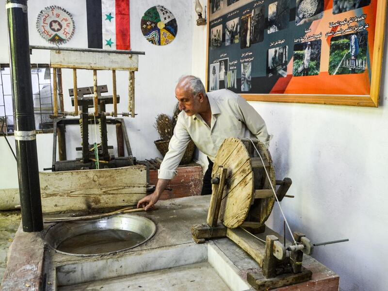 In the green hills of Deir Mama, Saud, his wife and three sons have been making silk for decades. They would raise silk worms in the spring, watching them munch on mulberry tree leaves and slowly build their thick cocoons, before spinning the thread and weaving those coils into fine cloth. MAHER AL MOUNES / AFP