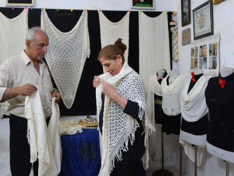 Muhammad Saud, a 65-year-old Syrian silk farmer, handweaves silk threads on a loom at his home workshop in the village of Deir Mama, in west-central Syria on June 22, 2020. MAHER AL MOUNES / AFP