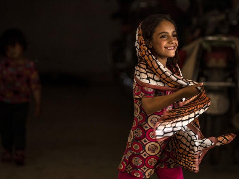 A girl holds her shawl while walking in a hallway at a school building where Syrians -- displaced from the area of Ras al-Ain by the Turkish offensive on the northeast -- are staying in the city of Hasakah, on June 30, 2020. Delil SOULEIMAN / AFP