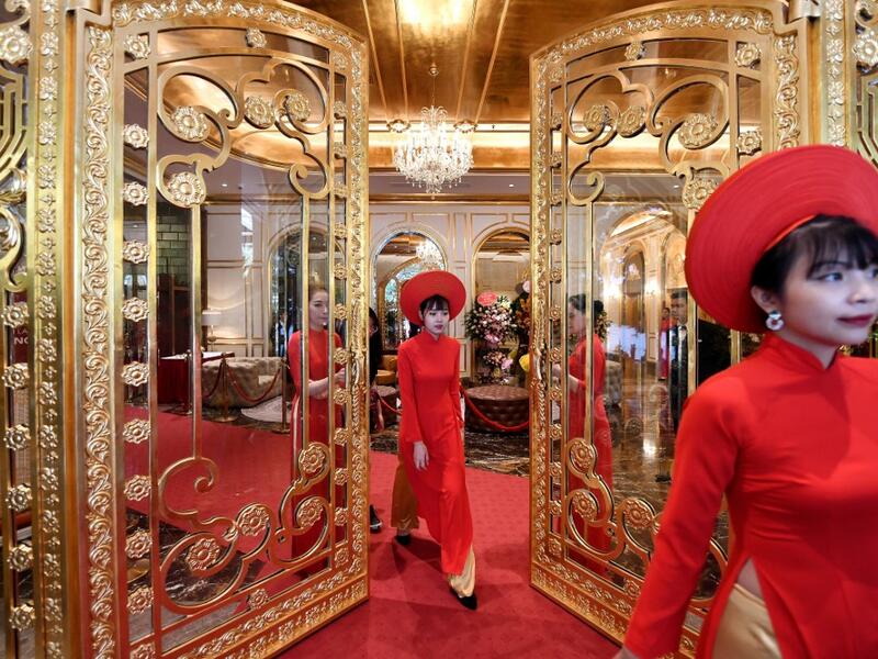 Staff wait to welcome guests in the lobby of the newly-inaugurated Dolce Hanoi Golden Lake hotel, the world's first gold-plated hotel, in Hanoi on July 2, 2020. Manan VATSYAYANA / AFP