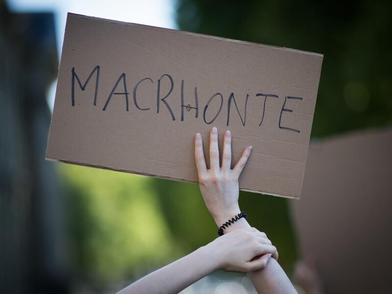 A protester holds a sign reading "Macrhonte", a play on words on the French President's name and the French word for "shame" during a demonstration called by feminist movements in Nantes, western France, on July 10, 2020, to denounce the nomination of French Interior Minister, facing rape accusations and French Justice Minister who criticised the #MeToo movement against sexual harassment. LOIC VENANCE / AFP