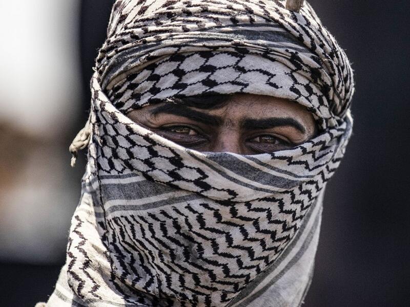 A man works at a makeshift refinery using burners to distill crude oil in the village of Bishiriya in the countryside near the town of Qahtaniya west of Rumaylan (Rmeilan) in Syria's Kurdish-controlled northeastern Hasakeh province, on July 19, 2020. DELIL SOULEIMAN / AFP