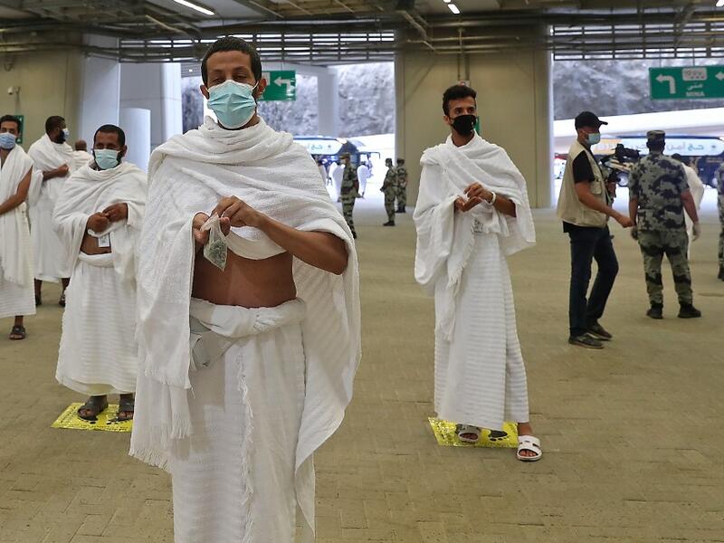 A picture taken on July 31, 2020 shows Muslim worshippers throwing pebbles as part of the symbolic al-A'qabah (stoning of the devil ritual) at the Jamarat Bridge during the Hajj pilgrimage in Mina, near Saudi Arabia's holy city of Mecca. STR / AFP
