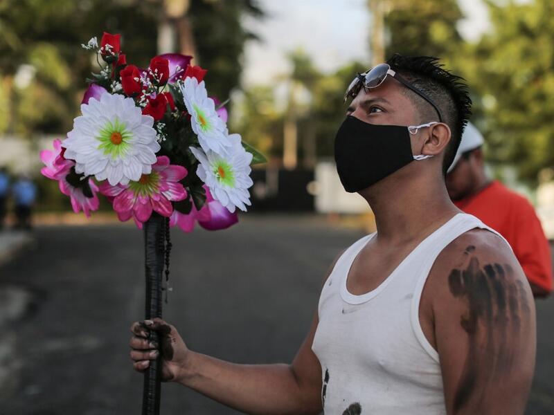 A Catholic faithful wears a face mask as a preventive measure against the spread of the novel coronavirus, COVID-19, during the opening of the ten-day celebration of the Santo Domingo de Guzman festival, outside the Las Sierritas de Santo Domingo church in Managua, on August 1, 2020. Despite the Catholic Church cancelling all religious activities due to the coronavirus pandemic, devotees gathered outside the church for the celebration.