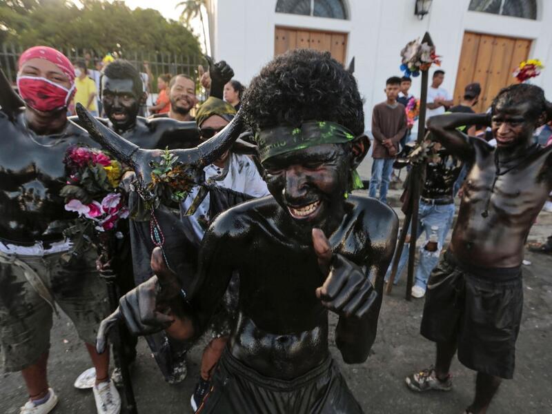 Catholic faithfuls smeared in burnt oil take part in the opening of the ten-day celebration of the Santo Domingo de Guzman festival, outside the Las Sierritas de Santo Domingo church in Managua, on August 1, 2020 amid the COVID-19 novel coronavirus pandemic. Despite the Catholic Church cancelling all religious activities due to the coronavirus pandemic, devotees gathered outside the church for the celebration. Inti OCON / AFP