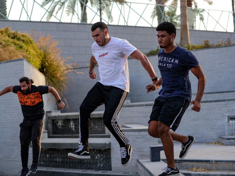 Hamzar Mekkaoui (L) , Achref Bejaoui (C) and a friend perform parkour, a sport that originated in France in the 1990s, which involves getting around urban obstacles with a fast-paced mix of jumping, vaulting, running and rolling, in the Qatari capital Doha, on August 11, 2020. Parkour, also known as free-running, has now found a small but committed following in Qatar despite evening temperatures that hover around 40 degrees Celsius (104 Fahrenheit) in summer and over-zealous security guards unfamiliar with 