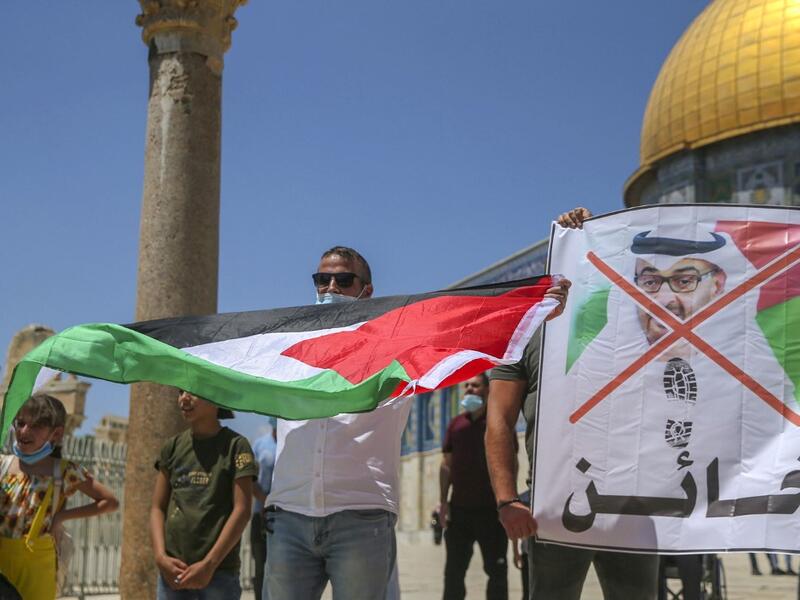 Palestinian protesters prepare to tear apart a portrait of Abu Dhabi Crown Prince Sheikh Mohammed bin Zayed al-Nahyan on August 14, 2020 at the al-Aqsa mosque compound in Jerusalem, during a protest against a US-brokered deal between Israel and the UAE to normalise relations. AFP