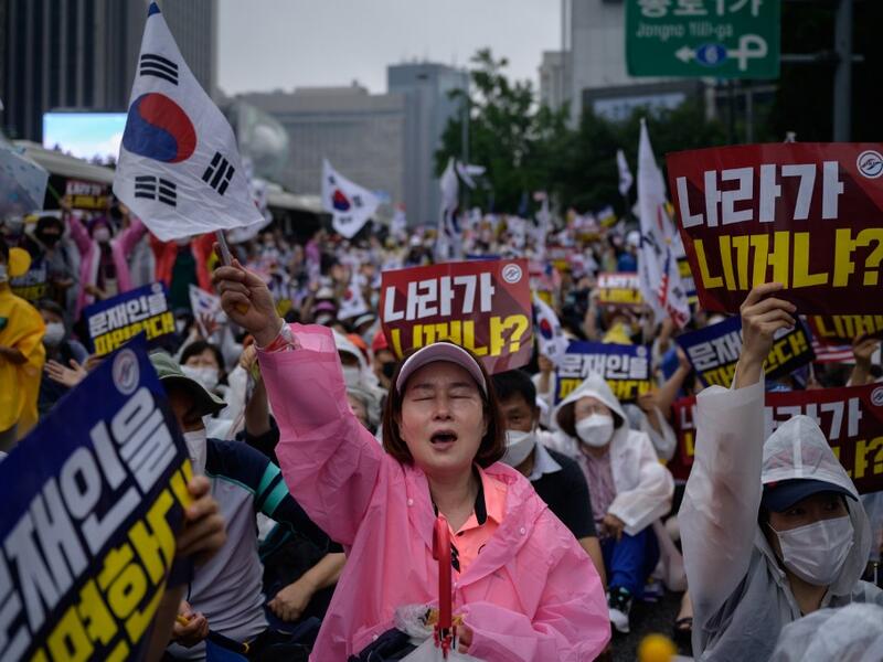 Members of pro-US conservative right-wing and religious christian groups wave flags and shout slogans during an anti-government rally in the central Gwanghwamun area of Seoul on August 15, 2020. (AFP)