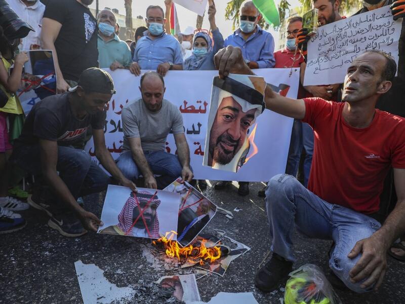 Palestinian protesters burn pictures of Abu Dhabi Crown Prince Sheikh Mohammed bin Zayed Al Nahyan (top) and Saudi Crown Prince Mohammed bin Salman, during a demonstration against the Emirati-Israeli agreement, in Ramallah in the occupied West Bank, on August 15, 2020. ABBAS MOMANI / AFP