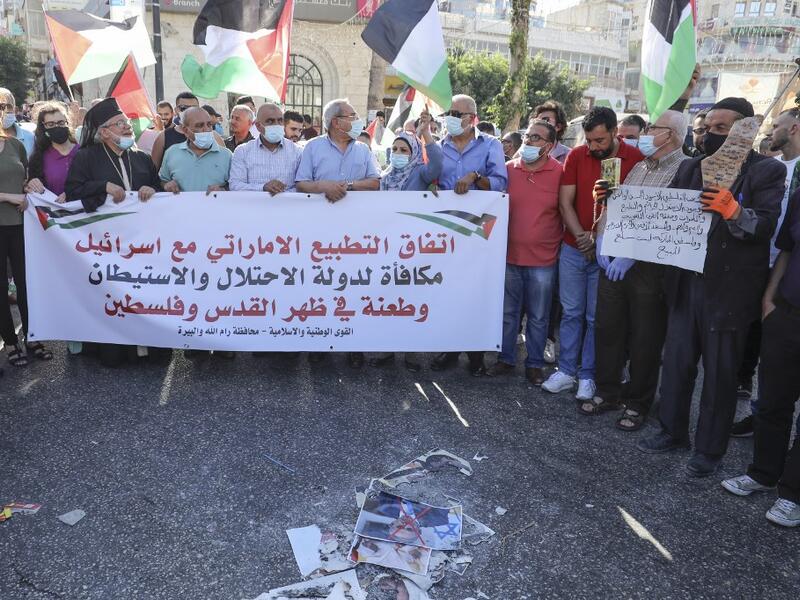Palestinian protesters lift a banner during a demonstration against the Emirati-Israeli agreement in Ramallah in the occupied West Bank, on August 15, 2020. ABBAS MOMANI / AFP