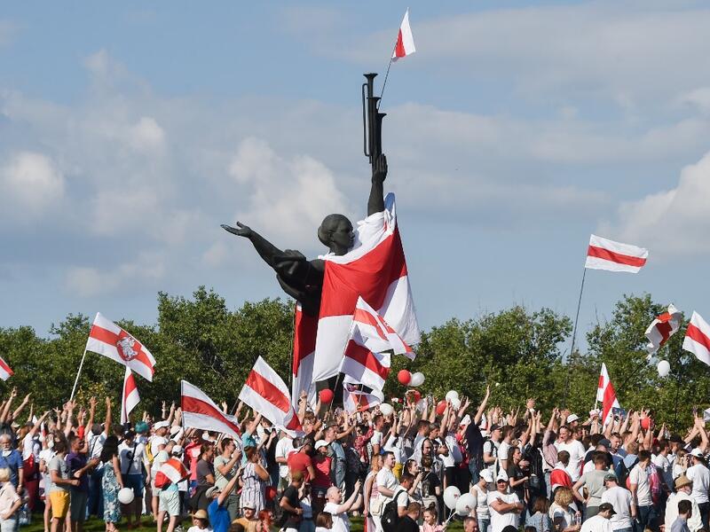 Belarus opposition supporters hold former white-red-white flags of Belarus used in opposition to the government, during a demonstration in central Minsk on August 16, 2020. The Belarusian strongman, who has ruled his ex-Soviet country with an iron grip since 1994, is under increasing pressure from the streets and abroad over his claim to have won re-election on August 9, with 80 percent of the vote. Sergei GAPON / AFP