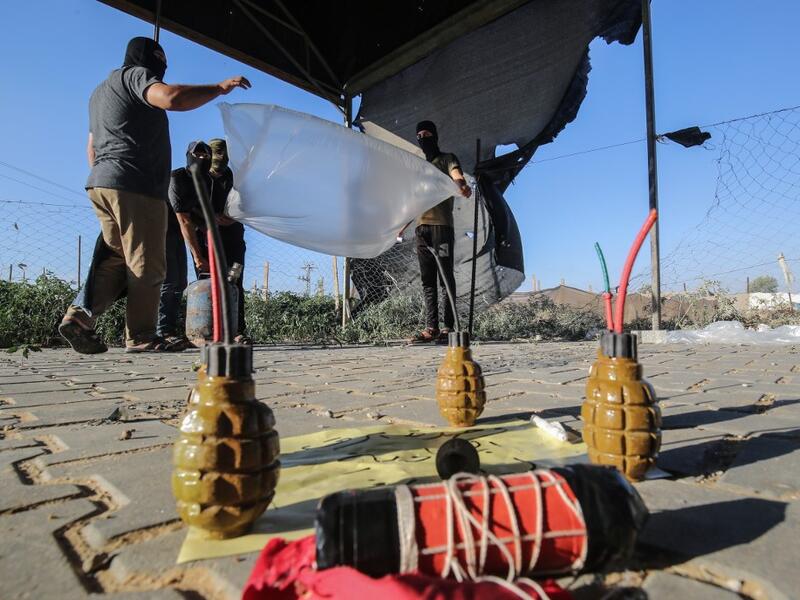Palestinians inflate plastic bags before being attached with incendiary devices and flown towards Israel, near Rafah along the border between the Gaza Strip and Israel on August 21, 2020. SAID KHATIB / AFP