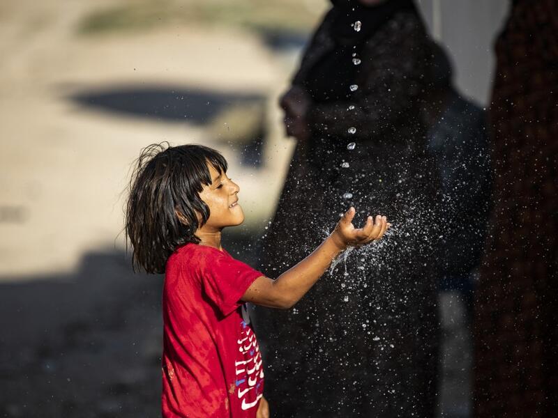 A Syrian boy plays with a stream of water, after humanitarian organisations delivered water to the area during a water outage, in Syria's northeastern city of Hasakah on August 22, 2020. As coronavirus spreads across northeast Syria, residents in Hasakeh have been caught up in the latest spat between Turkish forces to the north and Syrian Kurds it views as "terrorists". In October last year, Turkish forces occupied a 120-stretch (70-mile) stretch of land inside the Syrian border, including the Alouk power s