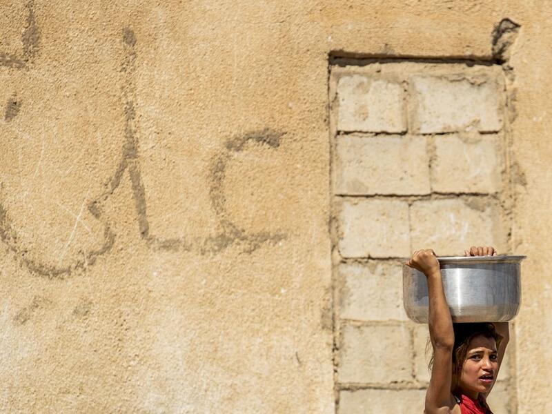 A displaced Syrian brings water back to their camp in a camp for the displaced in Syria's northeastern city of Hasakah on August 24, 2020. Delil SOULEIMAN / AFP