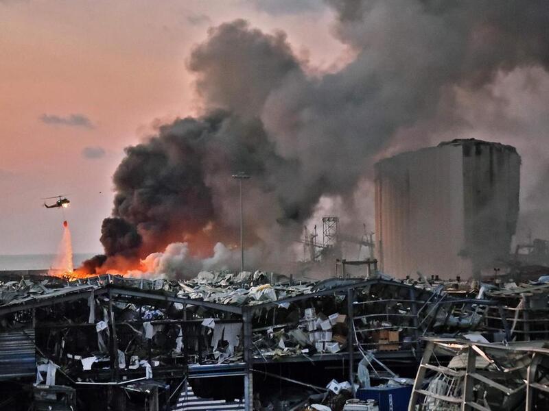 A helicopter puts out a fire at the scene of the explosion at the port of Lebanon's capital Beirut on August 4, 2020. AFP