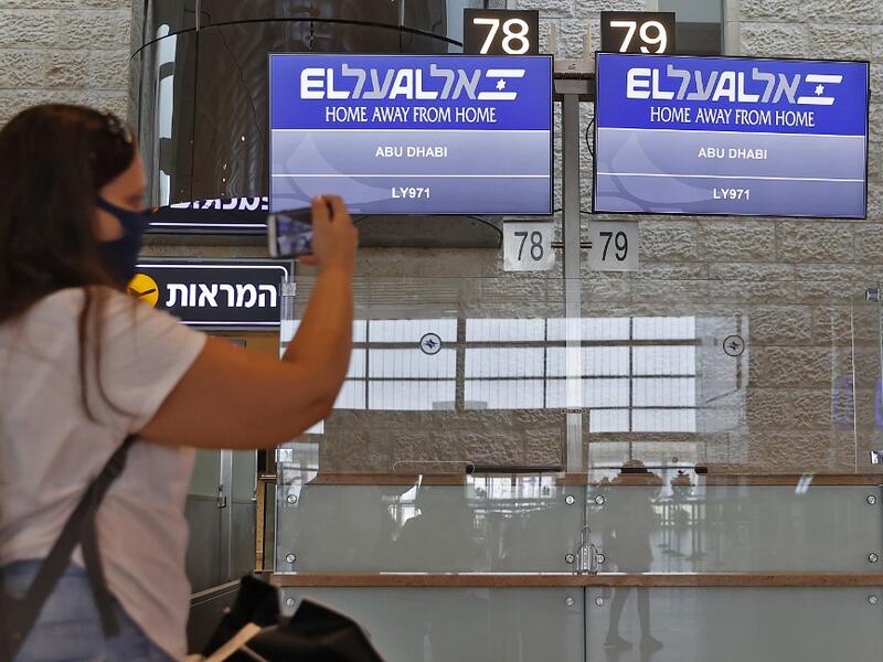 A picture taken on August 31, 2020, shows a passenger taking a picture of screens displaying the flight number of the first-ever commercial flight from Israel to the UAE at the Ben Gurion Airport near Tel Aviv, which will carry a US-Israeli delegation to the UAE following a normalisation accord. JACK GUEZ / AFP