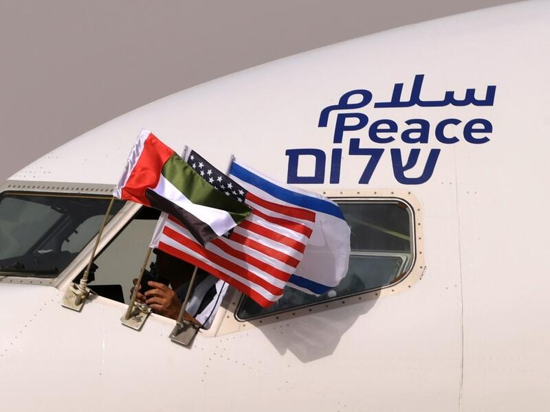 The Emirati, Israeli and US flags are picture attached to an air-plane of Israel's El Al, adorned with the word "peace" in Arabic, English and Hebrew, upon it's arrival at the Abu Dhabi airport in the first-ever commercial flight from Israel to the UAE, on August 31, 2020. KARIM SAHIB / AFP